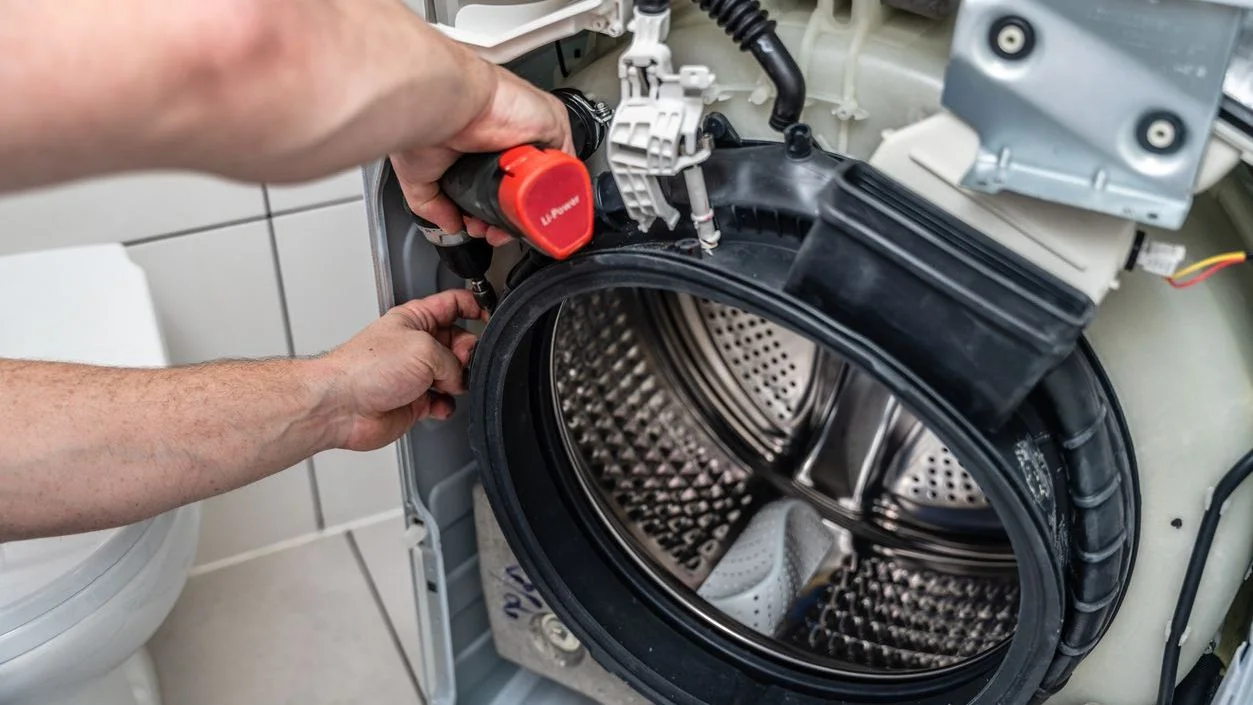 an appliance repair technician fixing a washing machine